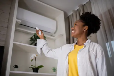 woman adjusting her AC temperatures