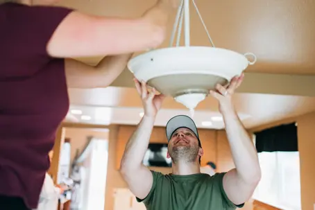 man fixing a light fixture